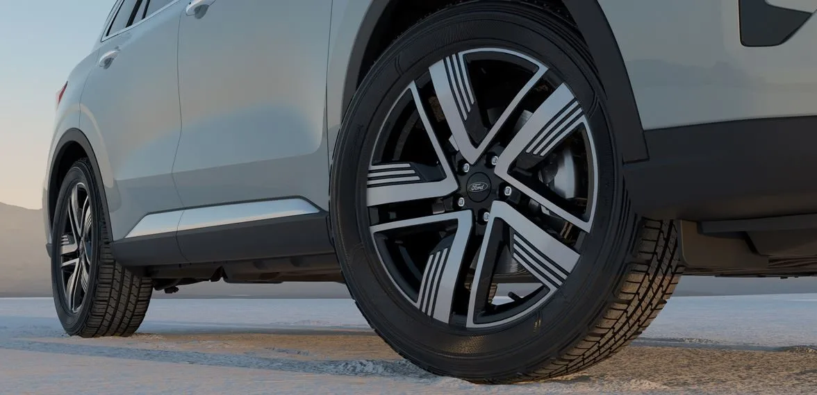 Detalhe das rodas de liga leve diamantadas de 19 polegadas do Novo Ford Territory 2026, com acabamento esportivo em preto e prata, pneus 235/50 e design aerodinâmico, destacando robustez e sofisticação em terreno plano.