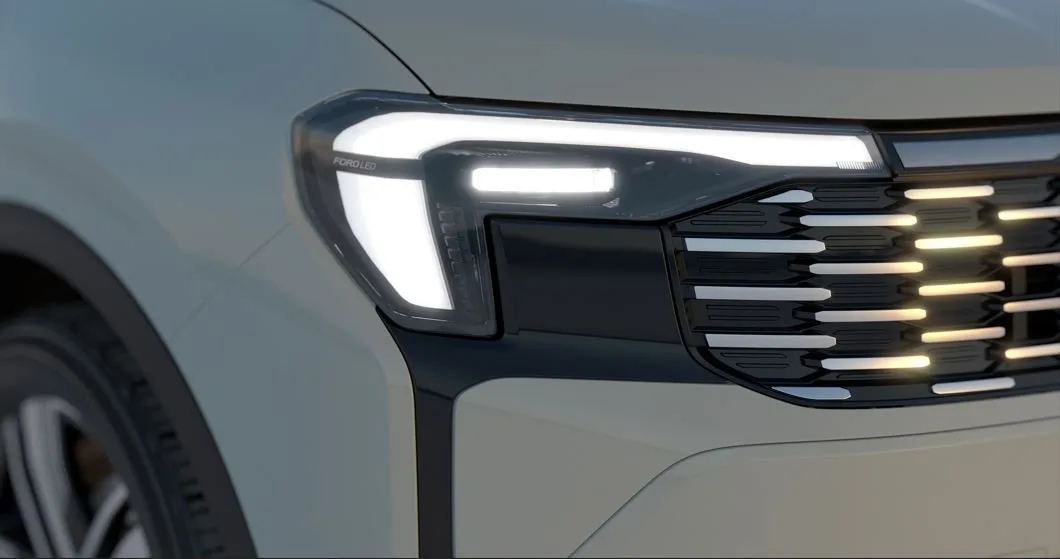 Detalhe do farol full-LED do Novo Ford Territory 2026, com assinatura luminosa em formato de L, tecnologia Ford LED e grade frontal com acabamento cromado e elementos iluminados, destacando o design moderno e a identidade visual do SUV.