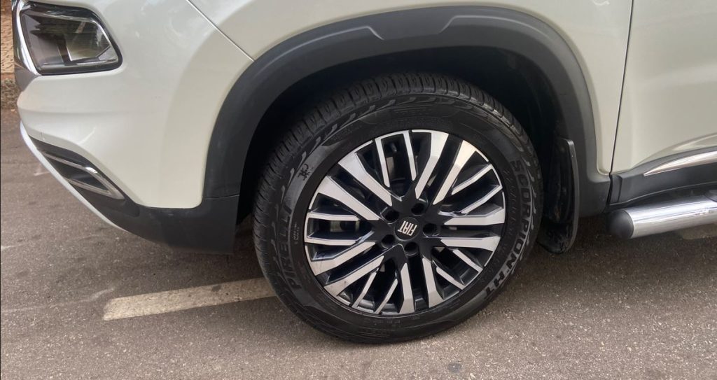 Detalhe da roda dianteira da Fiat Toro Ranch 2.2 Turbodiesel, com aro de 18 polegadas diamantado e pneus Pirelli Scorpion ATR. O design exclusivo da roda combina acabamento escurecido e prateado, realçando a robustez e sofisticação da picape.