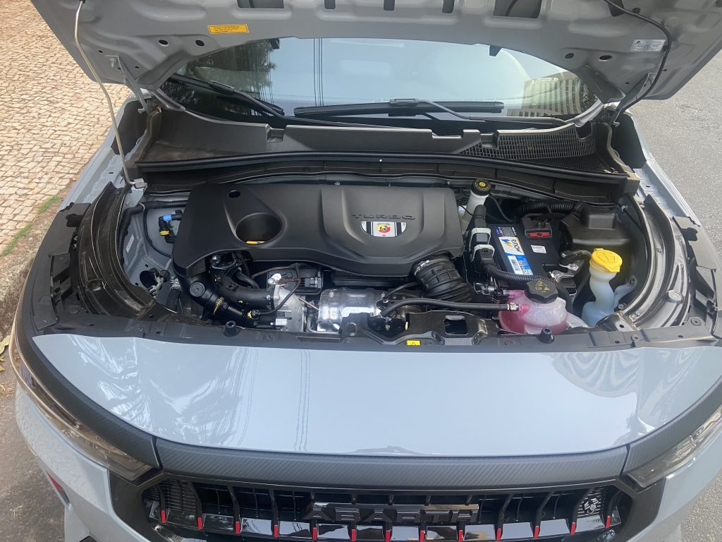 Motor Turbo 270 do Fastback Abarth 2025 com 185 cv, destaque para o emblema Abarth e componentes de alto desempenho sob o capô.