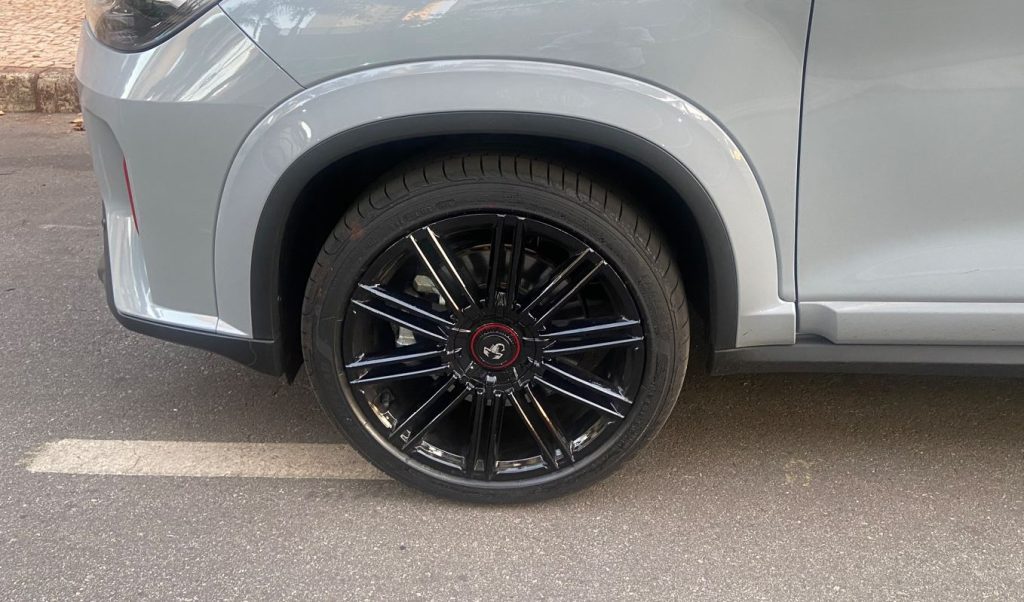 Roda de liga leve preta de 18 polegadas do Fastback Abarth 2025 com acabamento brilhante e emblema do escorpião no centro.
