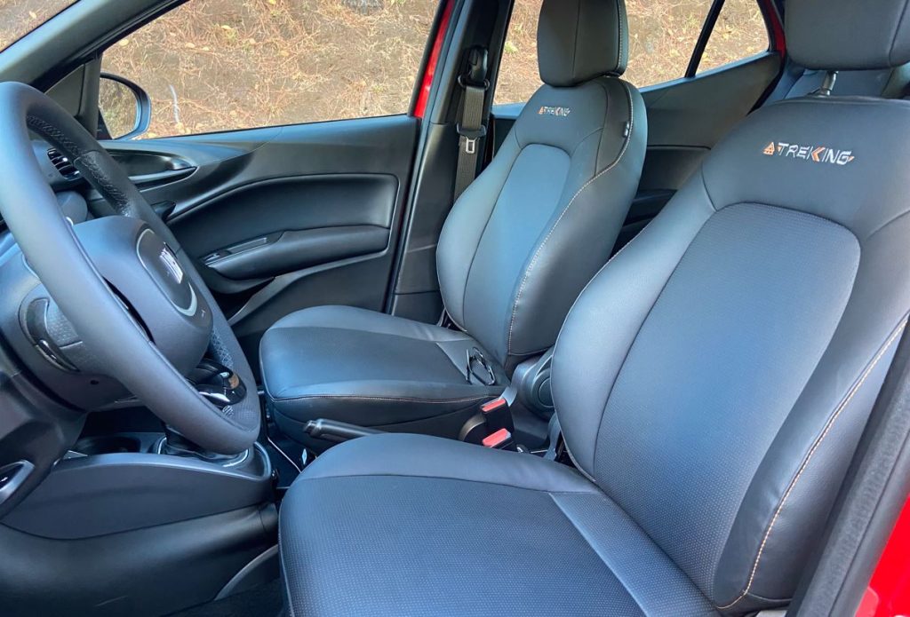 Detalhe dos bancos dianteiros do Fiat Argo Trekking 2026, com revestimento escurecido, costuras contrastantes e logotipo Trekking bordado no encosto.