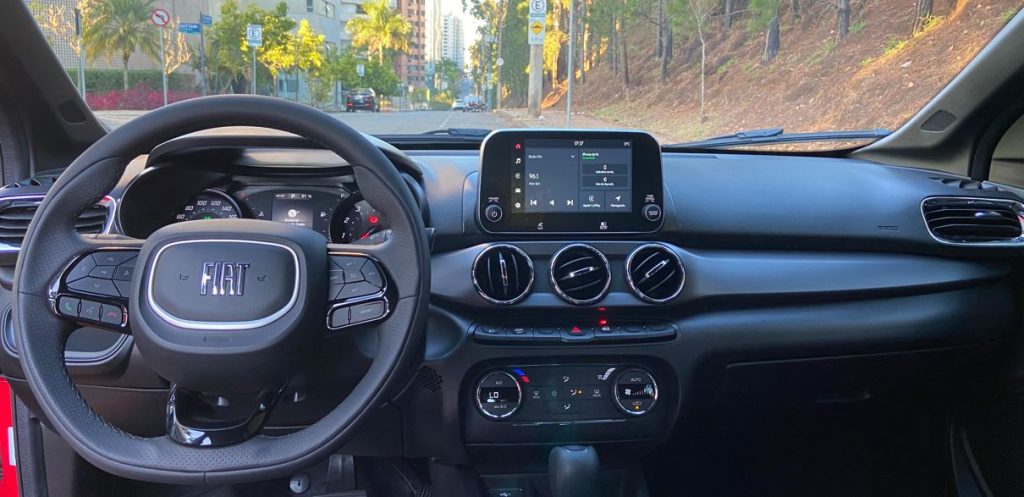 Painel frontal do Fiat Argo Trekking 2026 com volante multifuncional, cluster analógico-digital, central multimídia flutuante de 7 polegadas e comandos do ar-condicionado digital automático.
