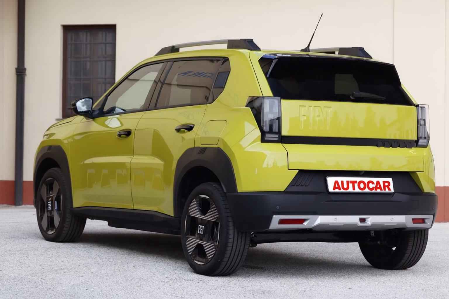 Traseira do Fiat Grande Panda 2026 em cor amarela, com lanternas verticais, rodas modernas e placa Autocar em destaque.
