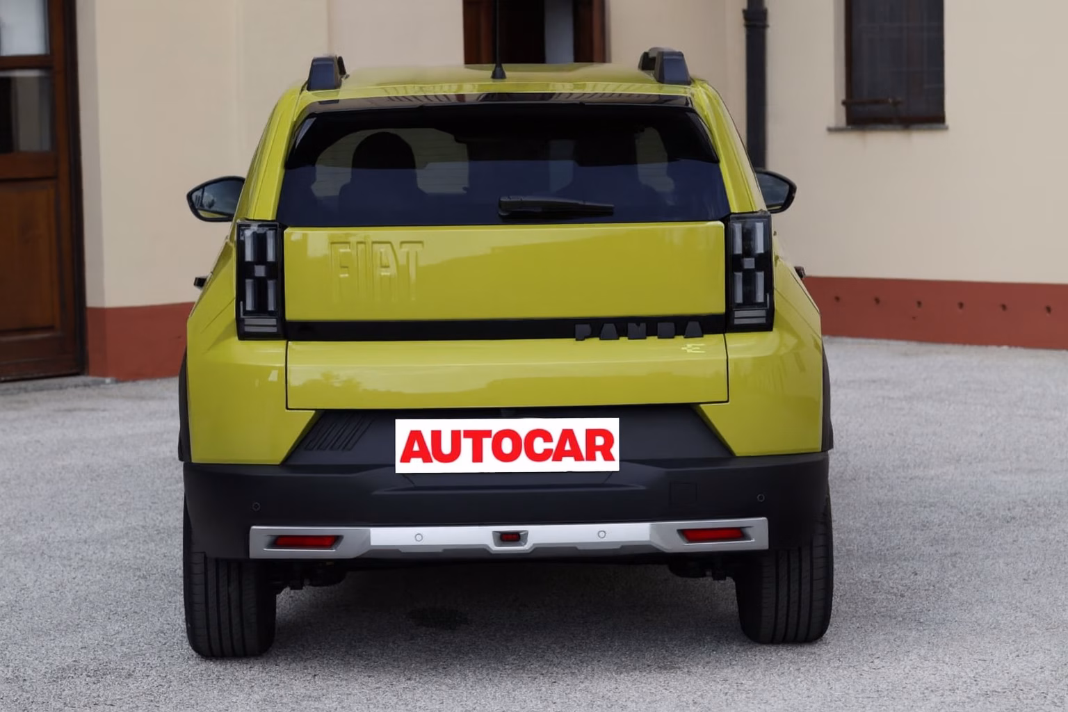 Traseira do Fiat Grande Panda 2026 em cor amarela, com lanternas verticais modernas, logo Fiat centralizado e placa Autocar.