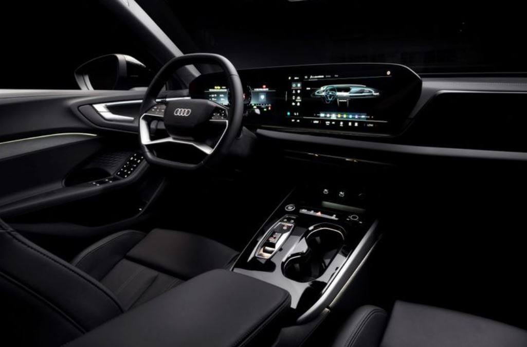 Interior do novo Audi A5 2025 com painel digital curvo, volante multifuncional, iluminação ambiente e console central refinado.