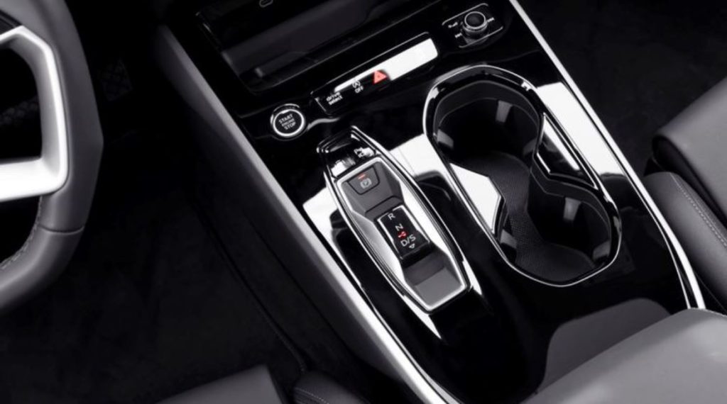 Console central do novo Audi A5 2025 com alavanca de câmbio eletrônica, botão Start/Stop, porta-copos duplo e acabamento black piano.