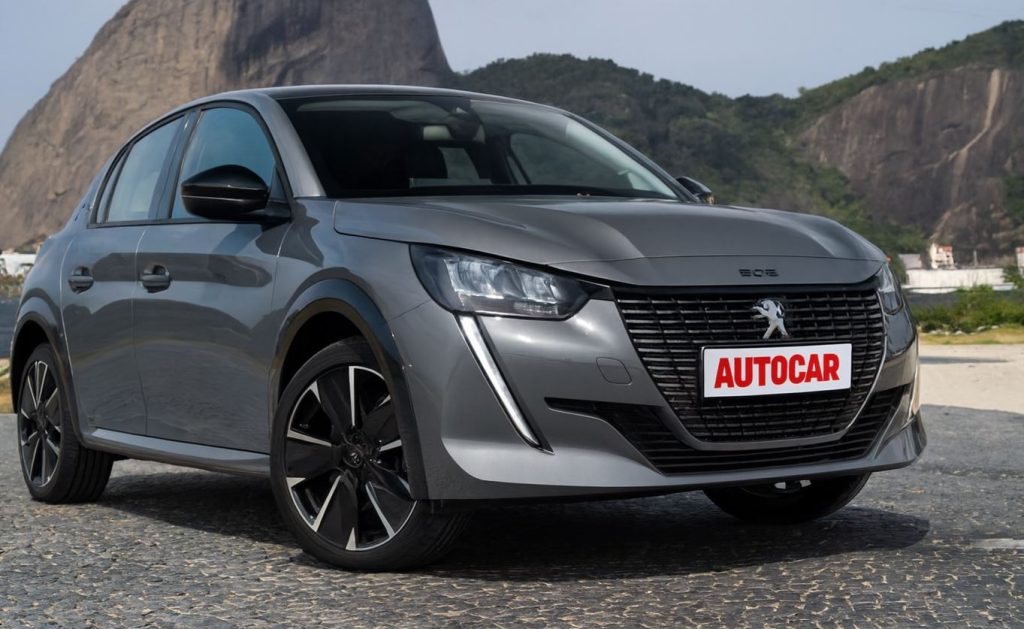Peugeot 208 híbrido cinza, com design moderno e placa personalizada, fotografado em destaque com foco no estilo e inovação do veículo.
