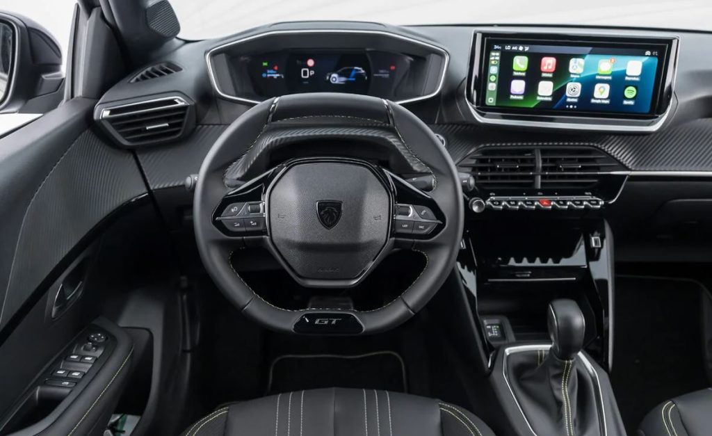 Painel do Peugeot 208 GT híbrido com volante esportivo, i-Cockpit 3D, central multimídia flutuante e acabamento sofisticado.