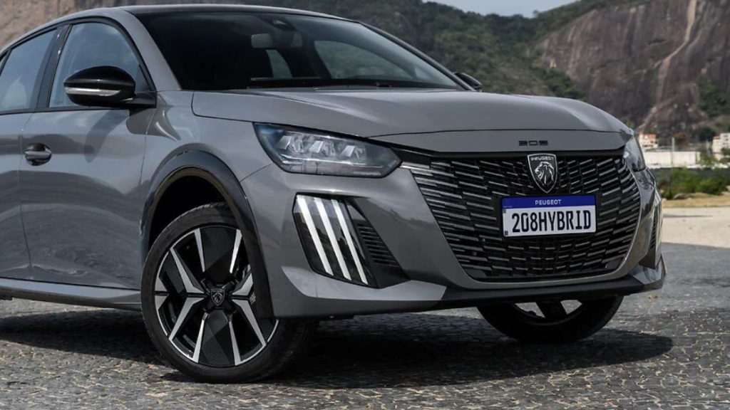 Destaque frontal do Peugeot 208 GT híbrido, com grade ampla em preto brilhante, faróis em LED e rodas diamantadas de 17 polegadas.