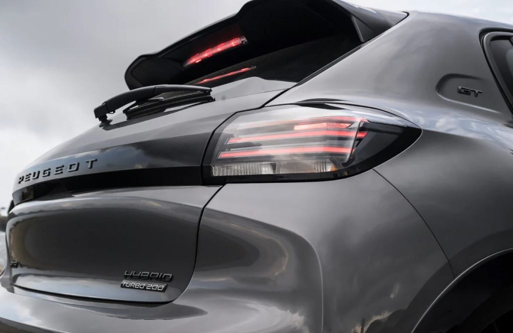 Traseira do Peugeot 208 GT híbrido com lanternas em LED acesas, logotipo da versão Turbo 200 e aerofólio esportivo com brake light.