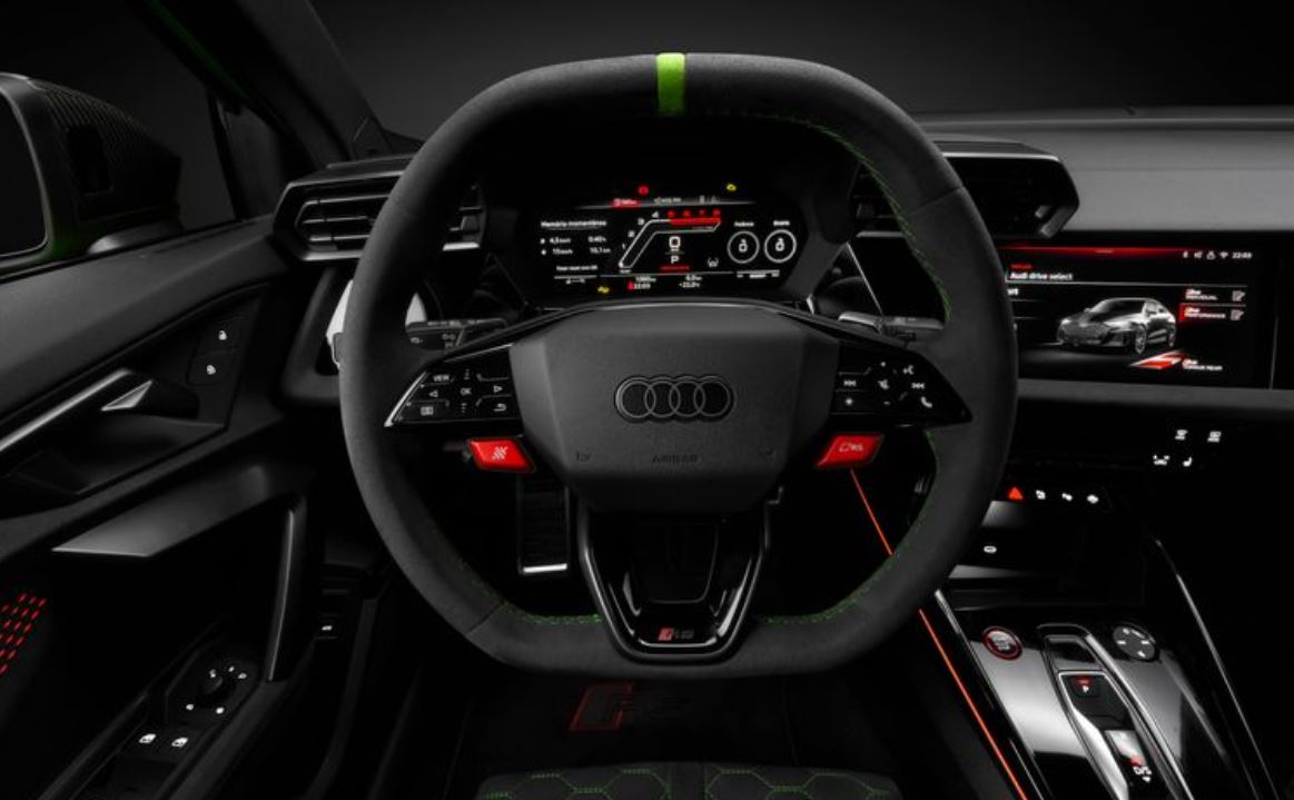 Painel digital do Audi RS 3 Sedan com volante esportivo multifuncional, marcação central verde, costura contrastante e Audi Virtual Cockpit Plus exibindo informações de performance.