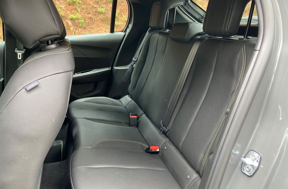 Interior traseiro do Peugeot 208 GT híbrido com bancos de couro ecológico, costura contrastante e espaço para três passageiros.