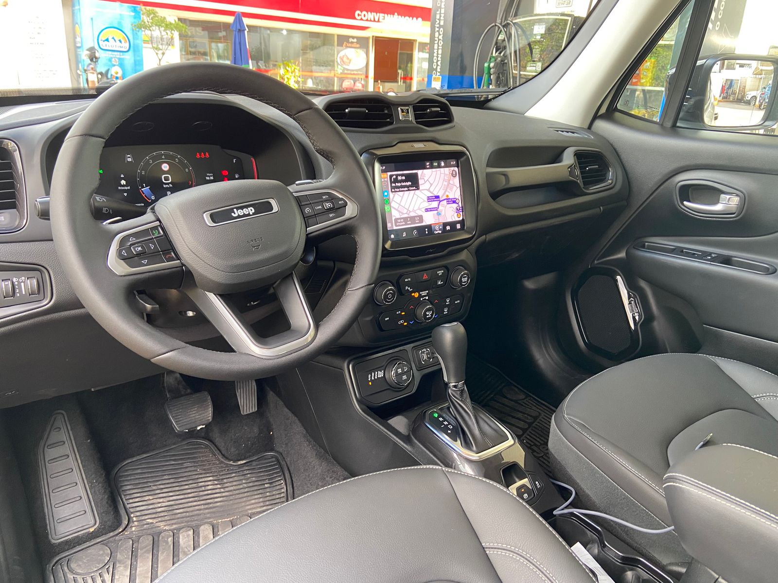 Painel do Jeep Renegade Willys 10 Anos com volante multifuncional, central multimídia com GPS, câmbio automático e comandos do ar-condicionado digital.