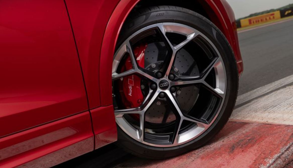 Detalhe da roda de liga leve do Audi RS Q8 Performance com pinça de freio vermelha, aro de 23” e acabamento em preto e alumínio.