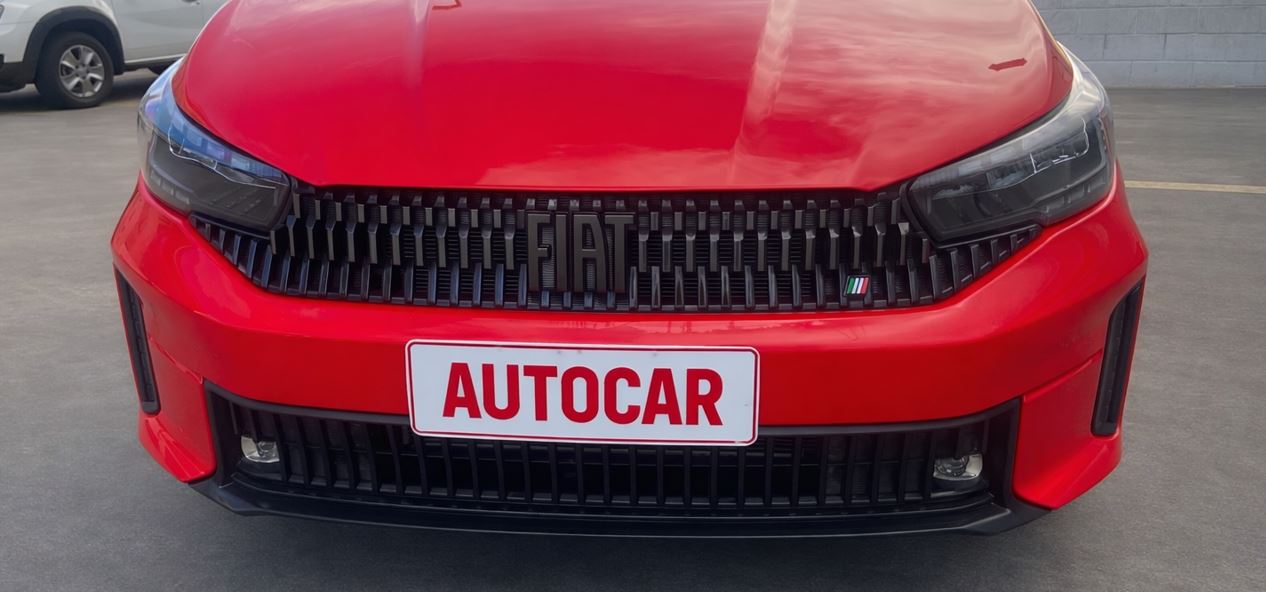 Detalhe da grade frontal do Fiat Cronos Drive 1.3 2026 com faróis full LED e placa personalizada AUTOCAR.