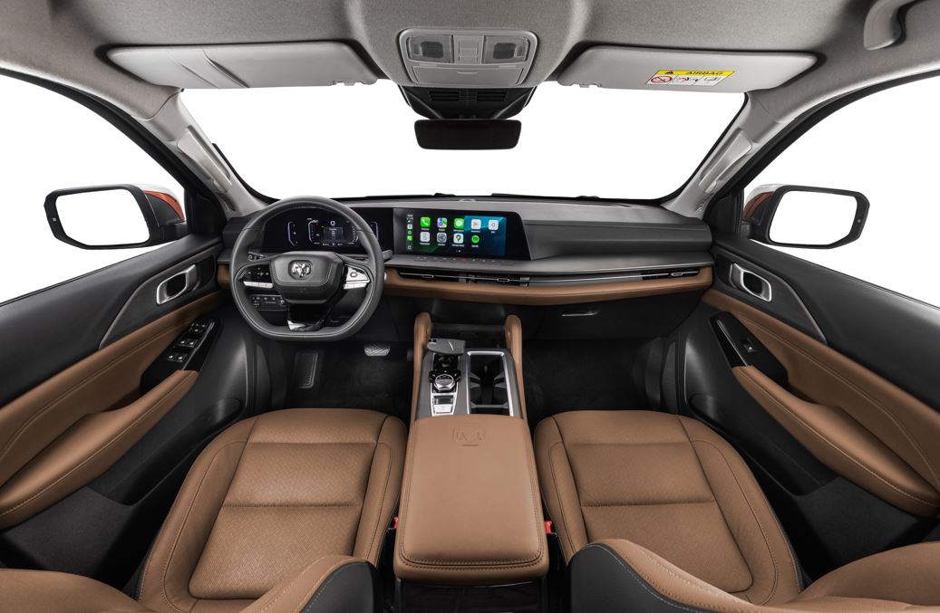 Interior da Ram Dakota Laramie 2026 com acabamento em couro marrom, painel digital integrado, central multimídia ampla e console central sofisticado.